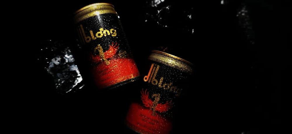 Diblong Energy Drink – Premium Power & Performance Two chilled cans of Diblong Energy Drink for men on a dark, wet background with water splashes.